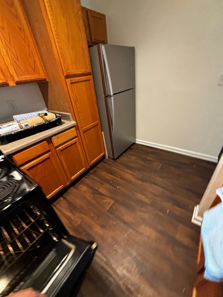 Kitchen before cleaning, with debris and dust on the floor