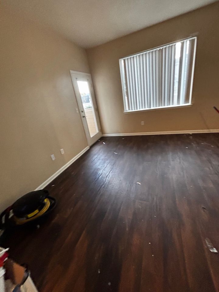 Living room before cleaning, with debris on the floor